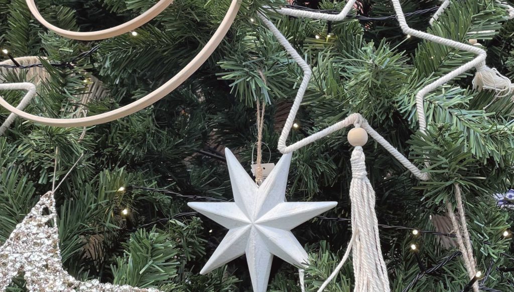 Weihnachtsbaum mit Elementen im Boho Stil geschmückt.