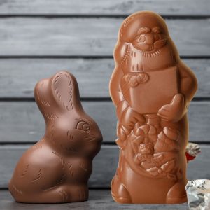 Ein Osterhase und ein Nikolaus aus verschiedenen Schokoladensorten zum Thema: Was ist wichtiger - Ostern oder Weihnachten.