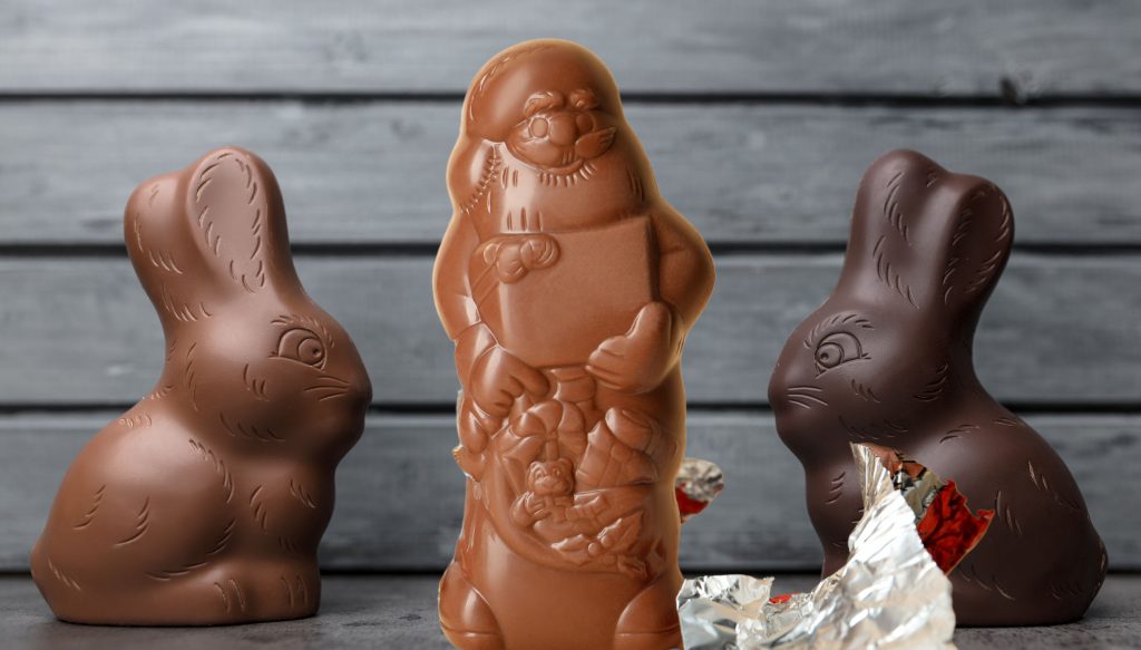Zwei Osterhasen und ein Nikolaus aus verschiedenen Schokoladensorten zum Thema: Was ist wichtiger - Ostern oder Weihnachten.