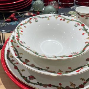 Festlich gedeckter Tisch mit Weihnachtsgeschirr für mehrere Gänge